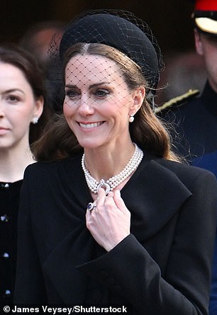 Kate wore a black hat with a large bow at the back and netting detail at the front, and pearl earrings