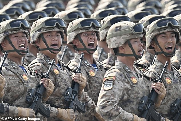 Chinese soldiers carry assault rifles with optical zooms during the procession on Wednesday