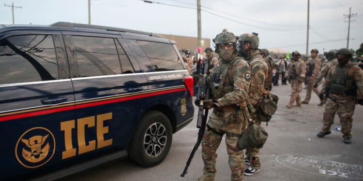 Immigration and Customs Enforcement agents armed with less-lethal weapons gather outside an ICE processing center during a protest in Broadview, Illinois, on Sept. 19, 2025.