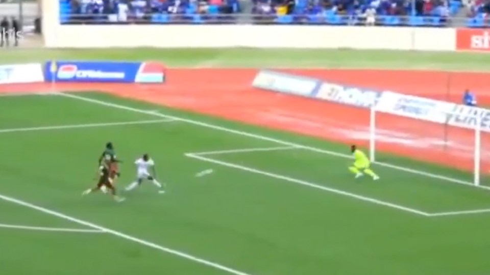 Soccer game, player kicking the ball toward the goal.