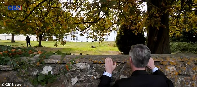 In footage that went viral, Jacob Rees-Mogg cranes his neck over a perimeter wall and calls out to a group of bemused men in the mid-distance. ¿Hallo, is this an illegal migrant place?¿