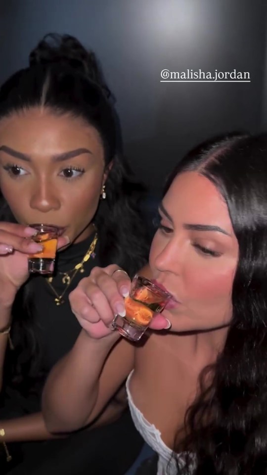 Two women drinking shots.