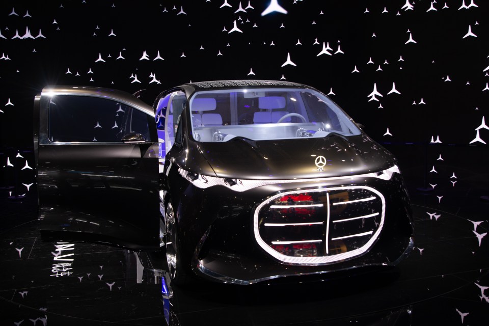 A Mercedes-Benz Vision luxury van with an open door at an auto show.