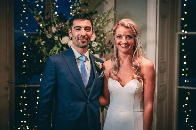 a bride and groom are posing for a picture at their wedding reception .