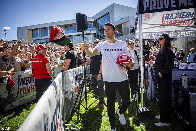 Charlie Kirk hands out hats before speaking at Utah Valley University in Orem, Utah, Wednesday - just minutes before he was shot and killed