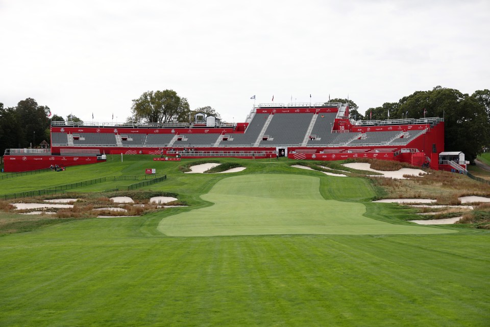 General view of the 18th hole at Black Course at Bethpage State Park Golf Course, with red grandstands and sponsors visible in the background.