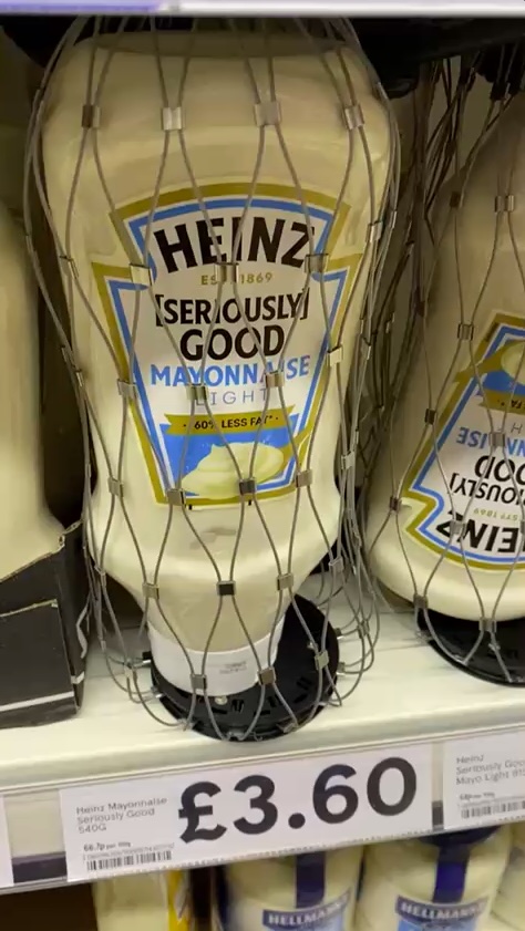 A bottle of Heinz "Seriously Good" mayonnaise, priced at £3.60, with an anti-theft mesh security tag around it.