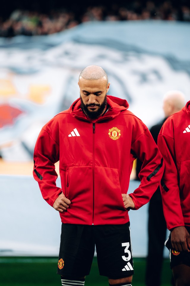 Manchester United player in red tracksuit.