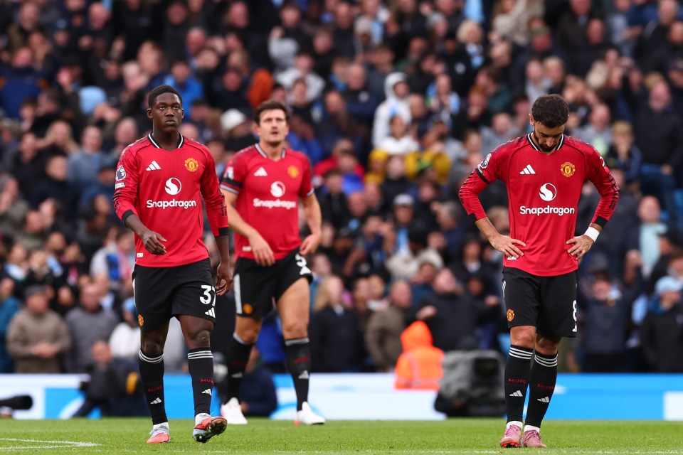 Dejected Manchester United players on the field.