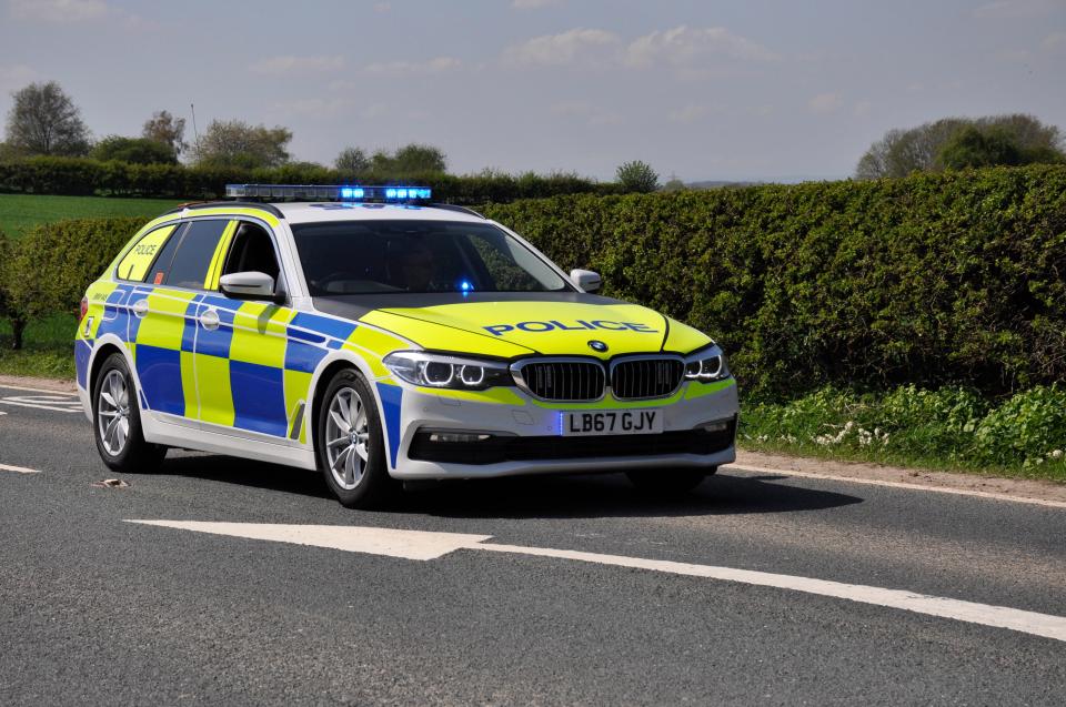 UK police car with blue lights on.