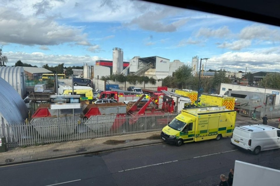 Emergency service vehicles, including ambulances and fire engines, gathered at a scrapyard.