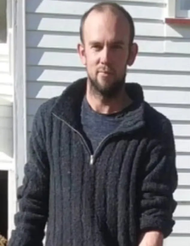 Photo of a man wearing a dark sweater.