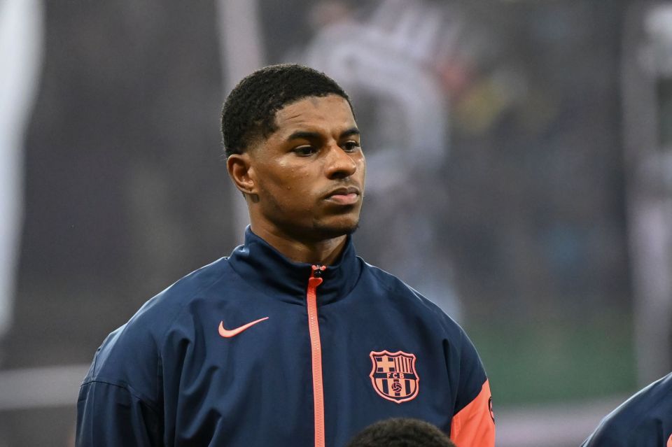 Marcus Rashford of FC Barcelona in a blue and orange jacket.