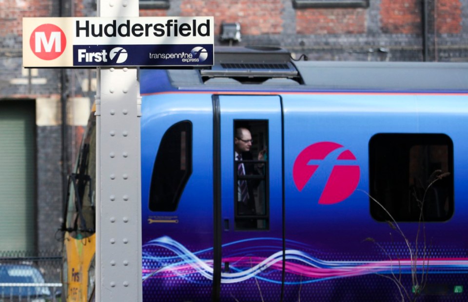 A guard looks from the window of a Trans Pennine Express train, operated by FirstGroup Plc, as it arrives at Huddersfield train station in Huddersfield, U.K., on Wednesday, May 30, 2012. FirstGroup Plc rose the most in more than three years after Britain's biggest train operator boosted full-year earnings 90 percent and said it would accelerate an asset disposal program in its bus division. Photographer: Chris Ratcliffe/Bloomberg via Getty Images