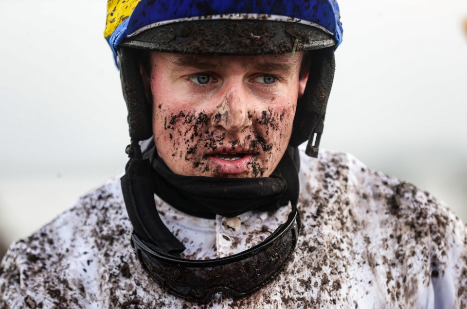 Jockey David Noonan covered in mud after a race.