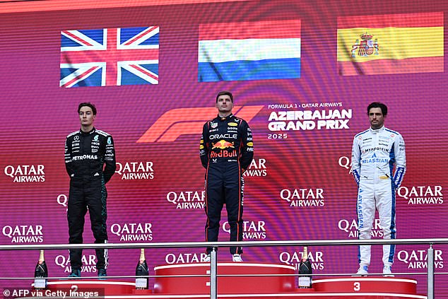 Max Verstappen stands proudly while being flanked by George Russell and Carlos Sainz