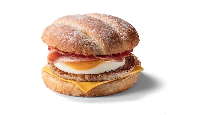 McDonald's Breakfast Roll with ketchup, bacon, egg, sausage, and cheese on a white background.
