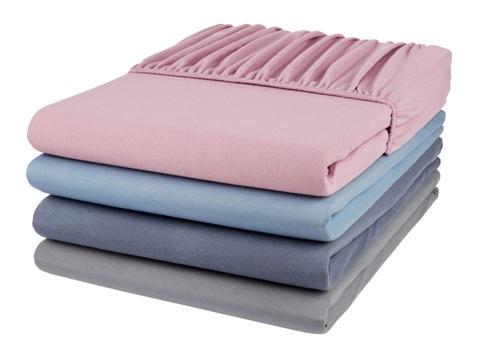 Stack of single fitted bed sheets in pink, light blue, dark blue, and gray.