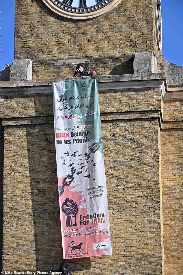 A protester has dramatically scaled the clock tower outside Kings Cross station with his dog