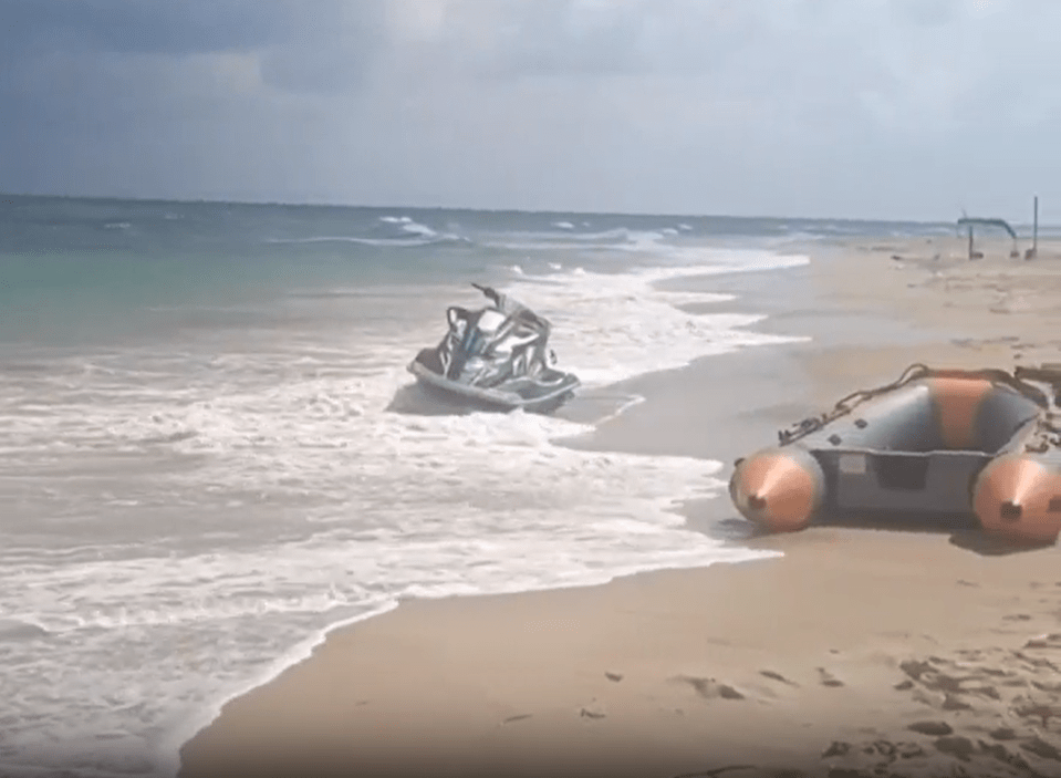 Jet ski and inflatable boat on a beach.