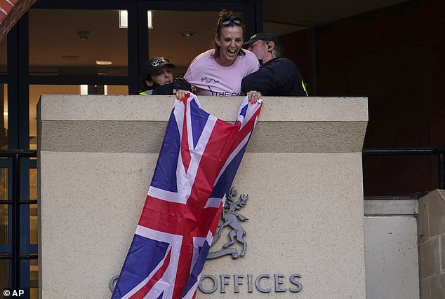 Footage shows Sarah White holding the flag above an entrance to Epping District Council's Civic Centre at 7.15pm on Sunday