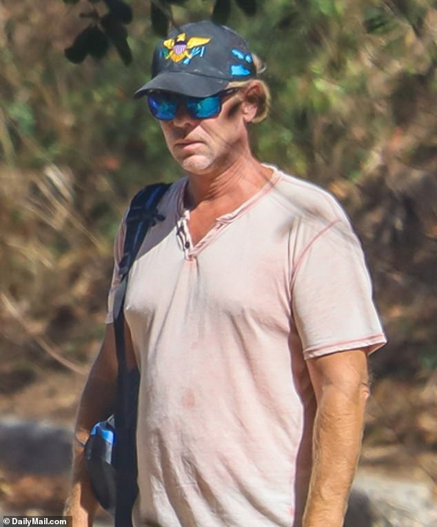 American Ryan Bane, pictured walking his dog on the US Virgin Islands in 2021. He has never been formally questioned by police after pleading his US Constitutional rights
