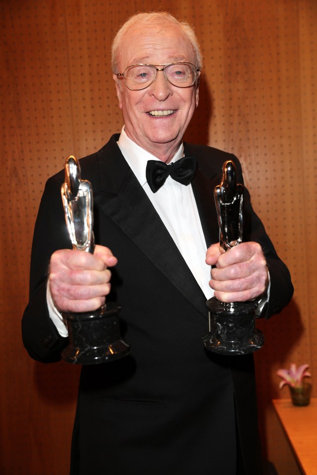 Sir Michael Caine holding two European Film Awards.
