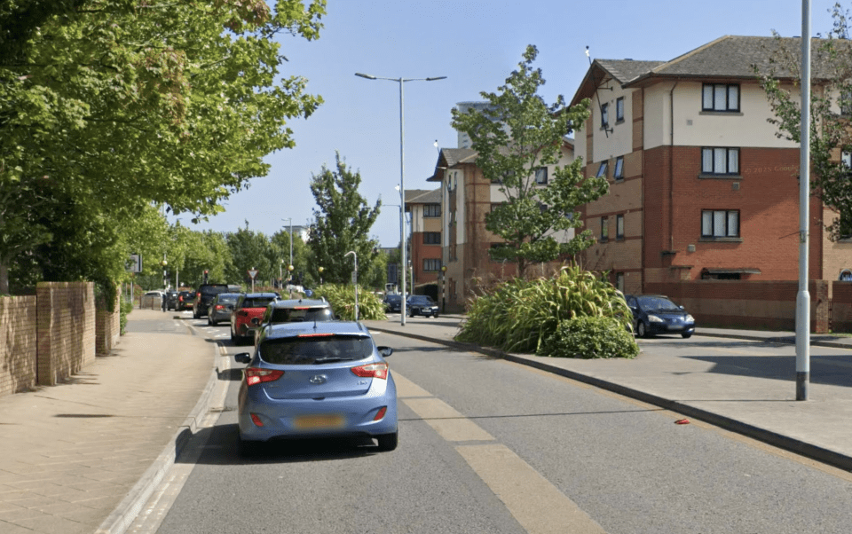 Dillwyn Street in Swansea, Wales, showing traffic on a sunny day with buildings on the right and trees on the left.
