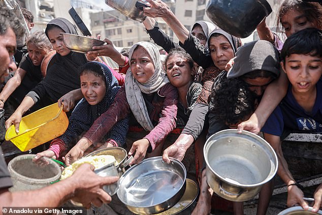 Palestinians carrying pans and bowls form a crowd to receive food aid provided by charity organizations in Gaza City, Gaza on September 2, 2025