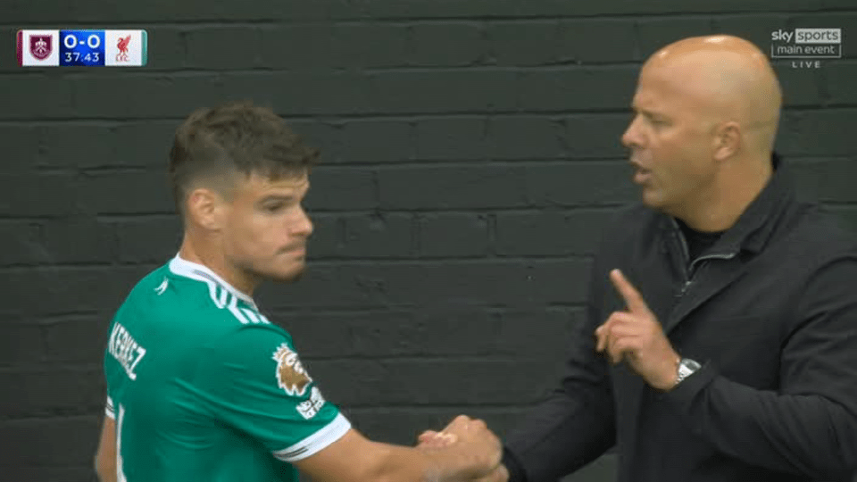 A soccer player and coach shaking hands.
