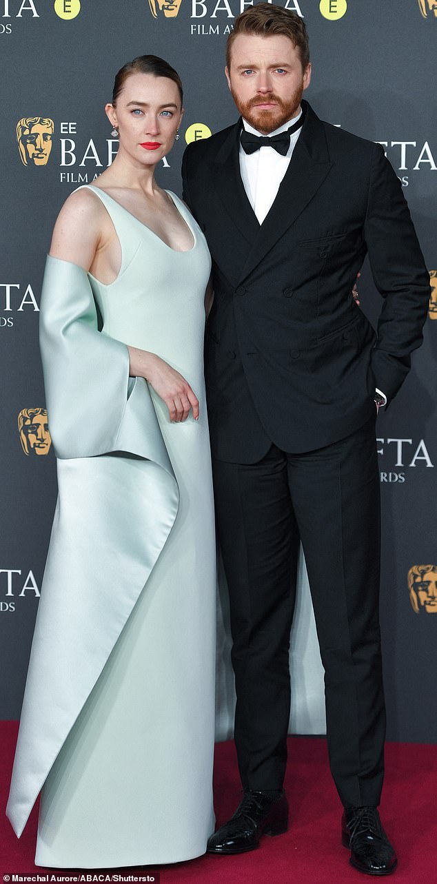 He and Little Women star Ms Ronan (pictured together at the BAFTAs in February), 31, who wed last year in Edinburgh, were seen for the first time with the newborn this month when they took a stroll with a pram
