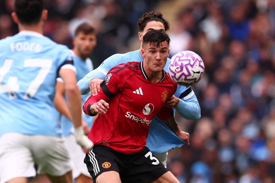 Benjamin Sesko of Manchester United under pressure from a Manchester City player during a Premier League match.