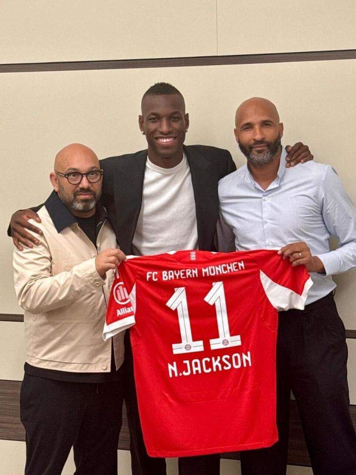 N. Jackson holding his new FC Bayern Munchen jersey with two other men.