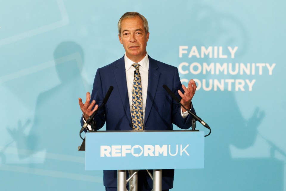 Nigel Farage speaking at a press conference from a podium with "Reform UK" written on it.