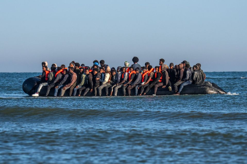 An image collage containing 1 images, Image 1 shows Migrants in a dinghy crossing the English Channel, with a police boat in the background