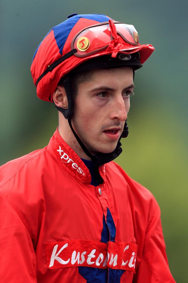 Jockey in red jacket and helmet.