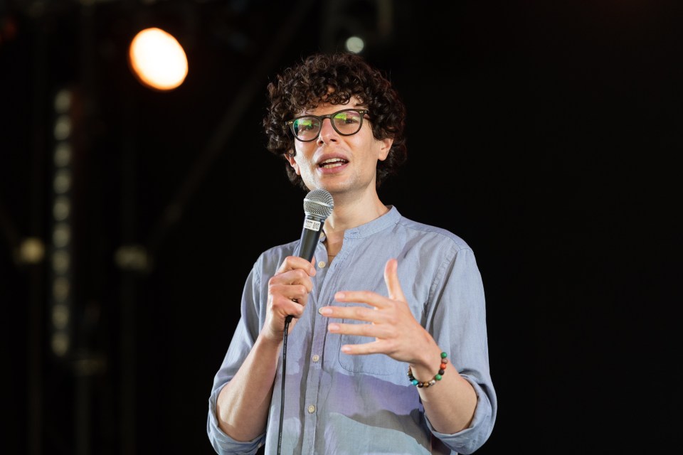Comedian Simon Amstell performing on stage.