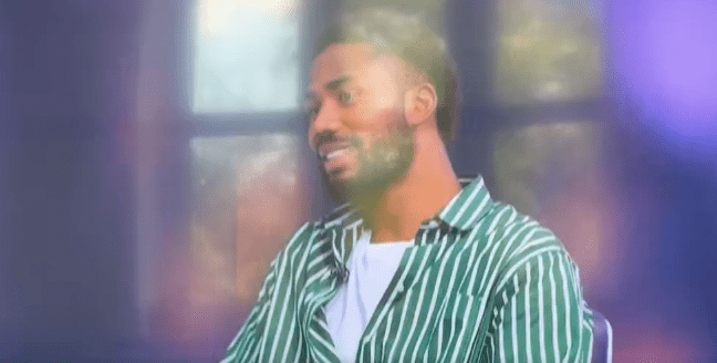 Man in striped shirt smiling.
