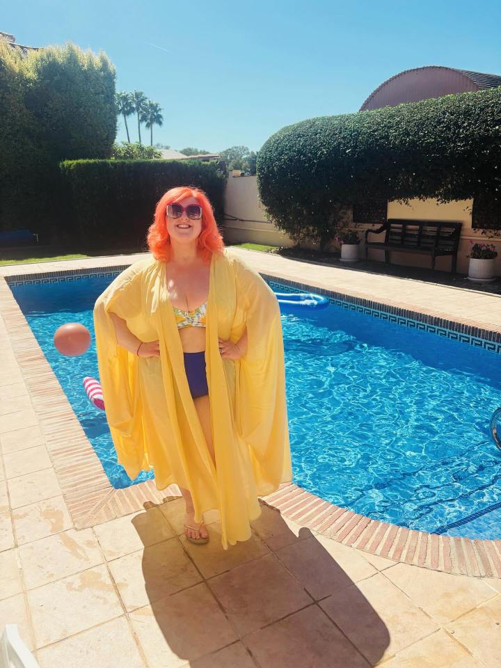 Michelle McManus in a bikini and yellow cover-up by a pool.