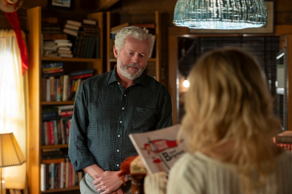 David Morse looks at Emily Alyn Lind as she reads a book.