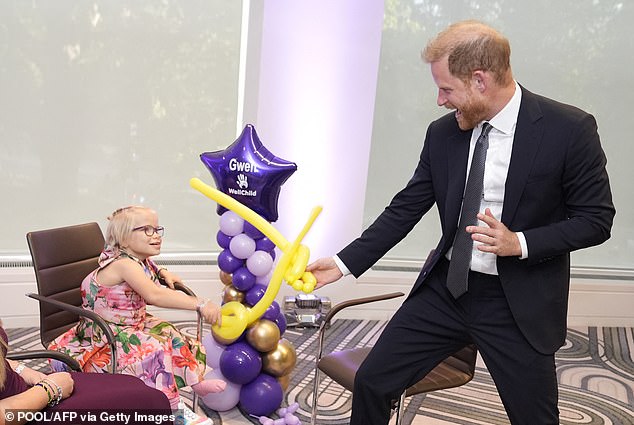 Prince Harry sword fights with children at WellChild awards after paying visit to late Queen's grave in Windsor while William and Kate were at official engagement just seven miles away