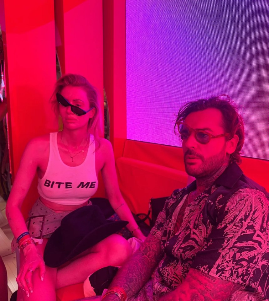 Olivia Attwood and a man sitting together in pink lighting.