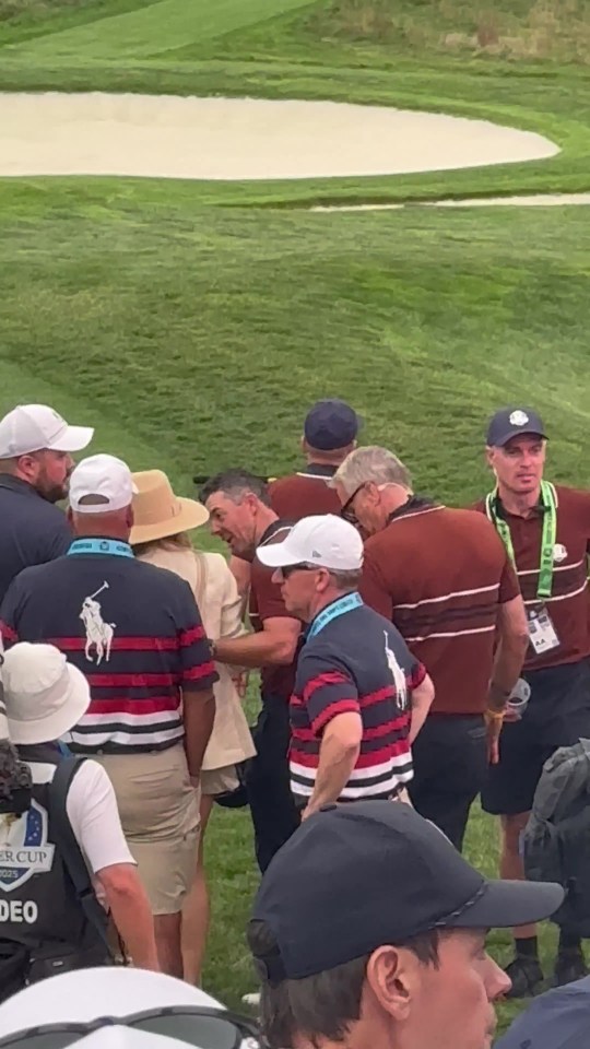 Rory McIlroy and Erica Stoll in a crowd on a golf course.