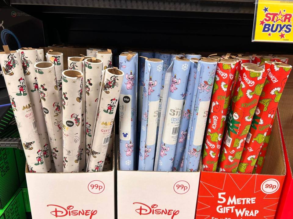 Assorted Disney wrapping paper in a store display.