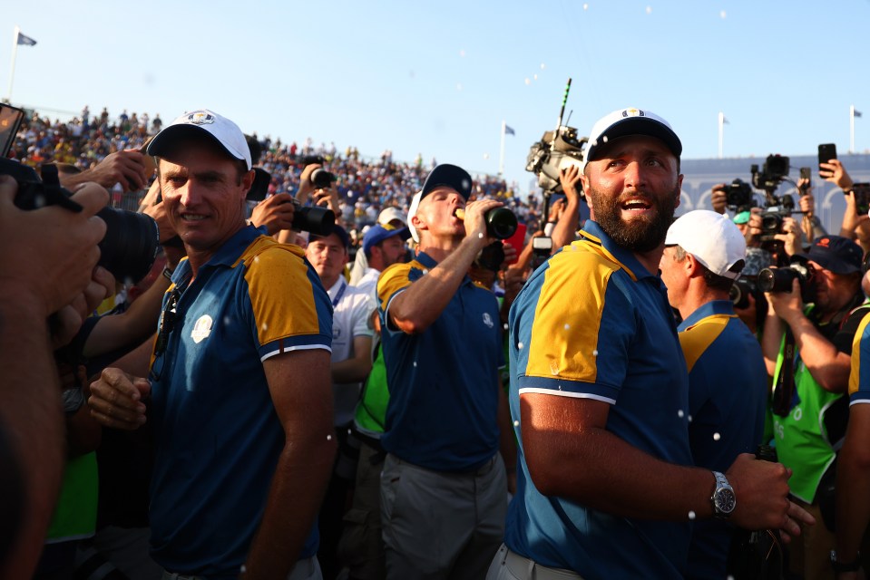 Nicolas Colsaerts, Jon Rahm, and other Team Europe members celebrating winning the Ryder Cup, with one man spraying champagne into his mouth.