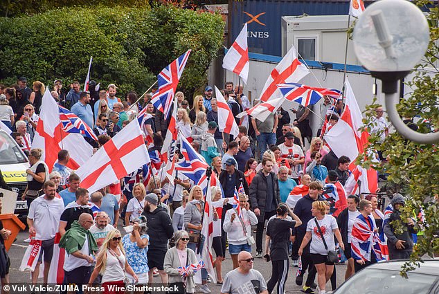 Crowds of anti-migrant demonstrators holding English flags and Union Jacks gather outside the Crowne Plaza hotel in West Drayton