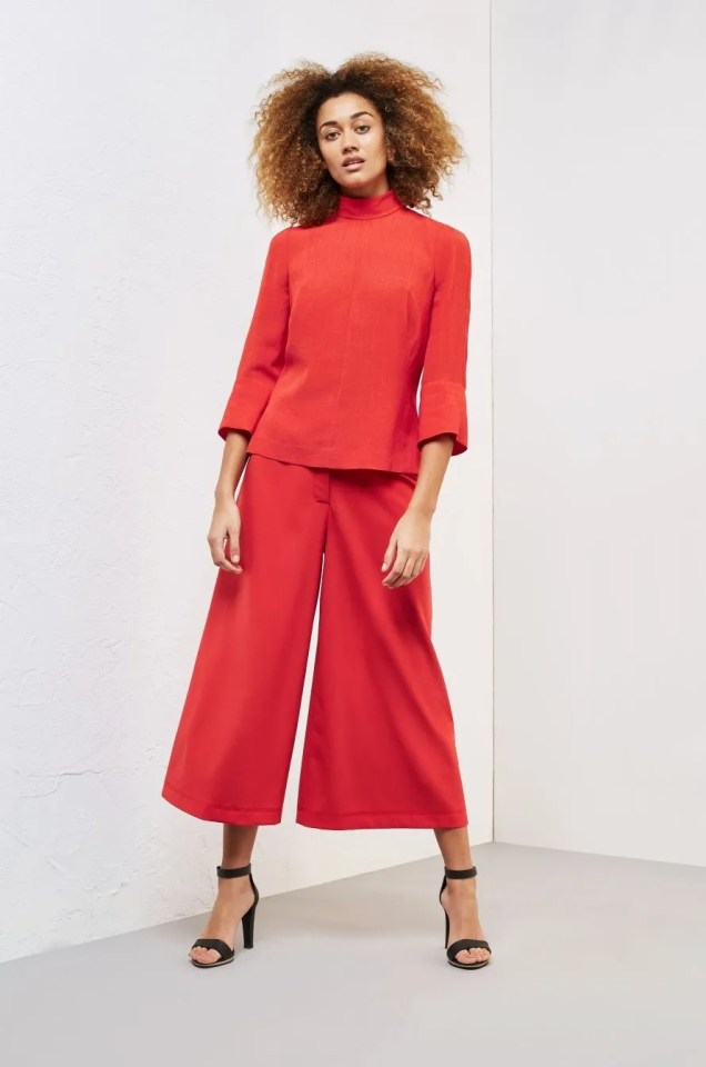 Woman in a red top and culottes.