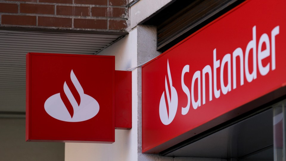 Santander Bank logo and name on a red sign on a building.