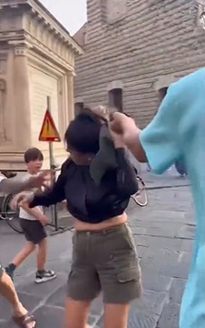 Woman adjusting her hair on a city street.
