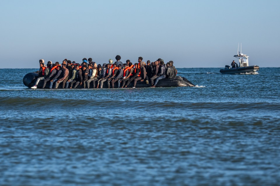 Migrants in a dinghy wait to cross the English Channel.